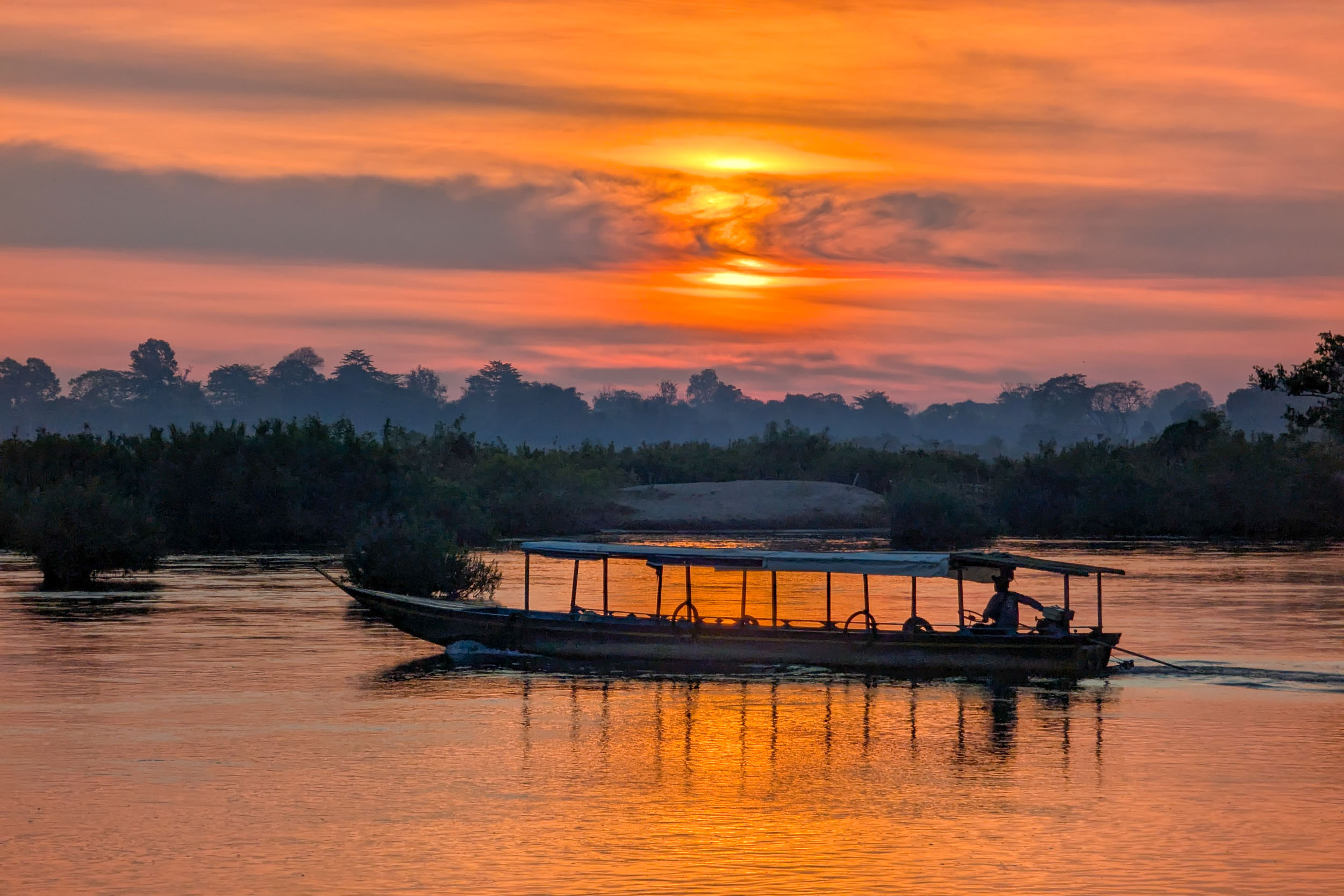 Sonnenaufgang mit Boot überm Mekong